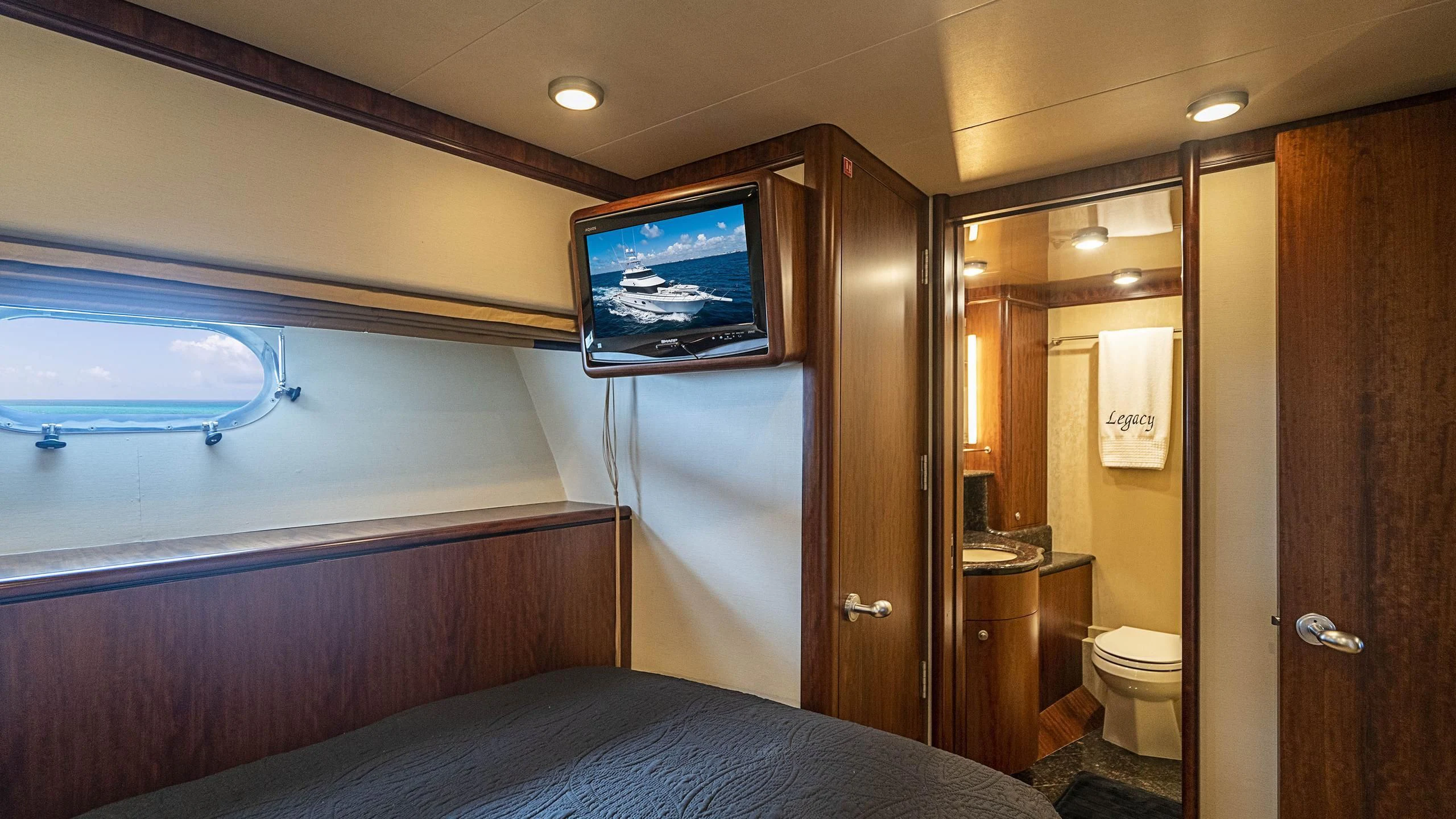 a bedroom with a bed and a television aboard GRAND LEGACY Yacht for Sale