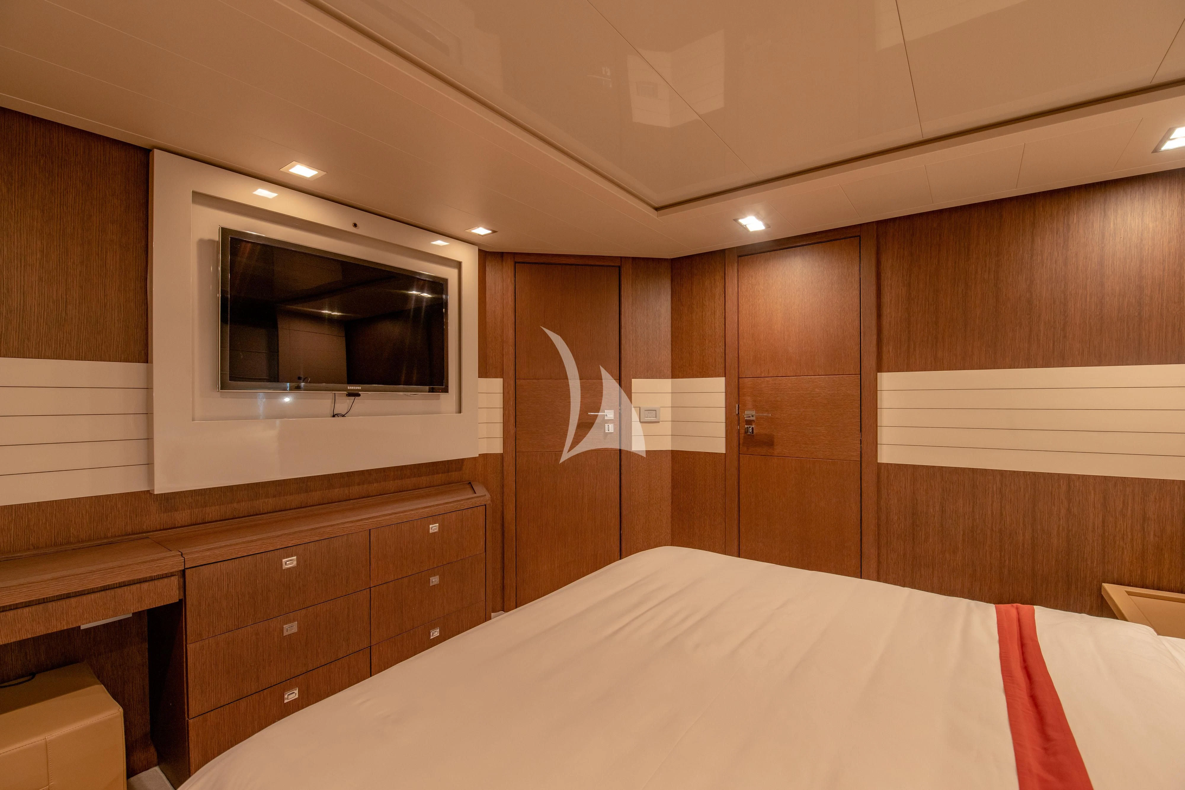 a bedroom with a bed and a television aboard INFINITAS Yacht for Charter