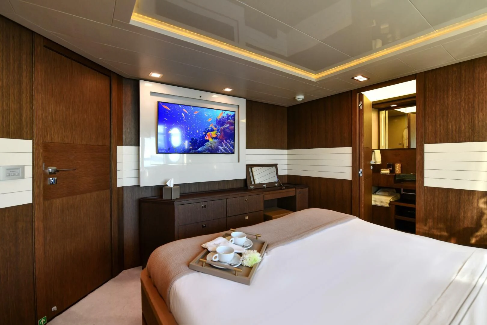 a room with a bed and a television aboard INFINITAS Yacht for Charter