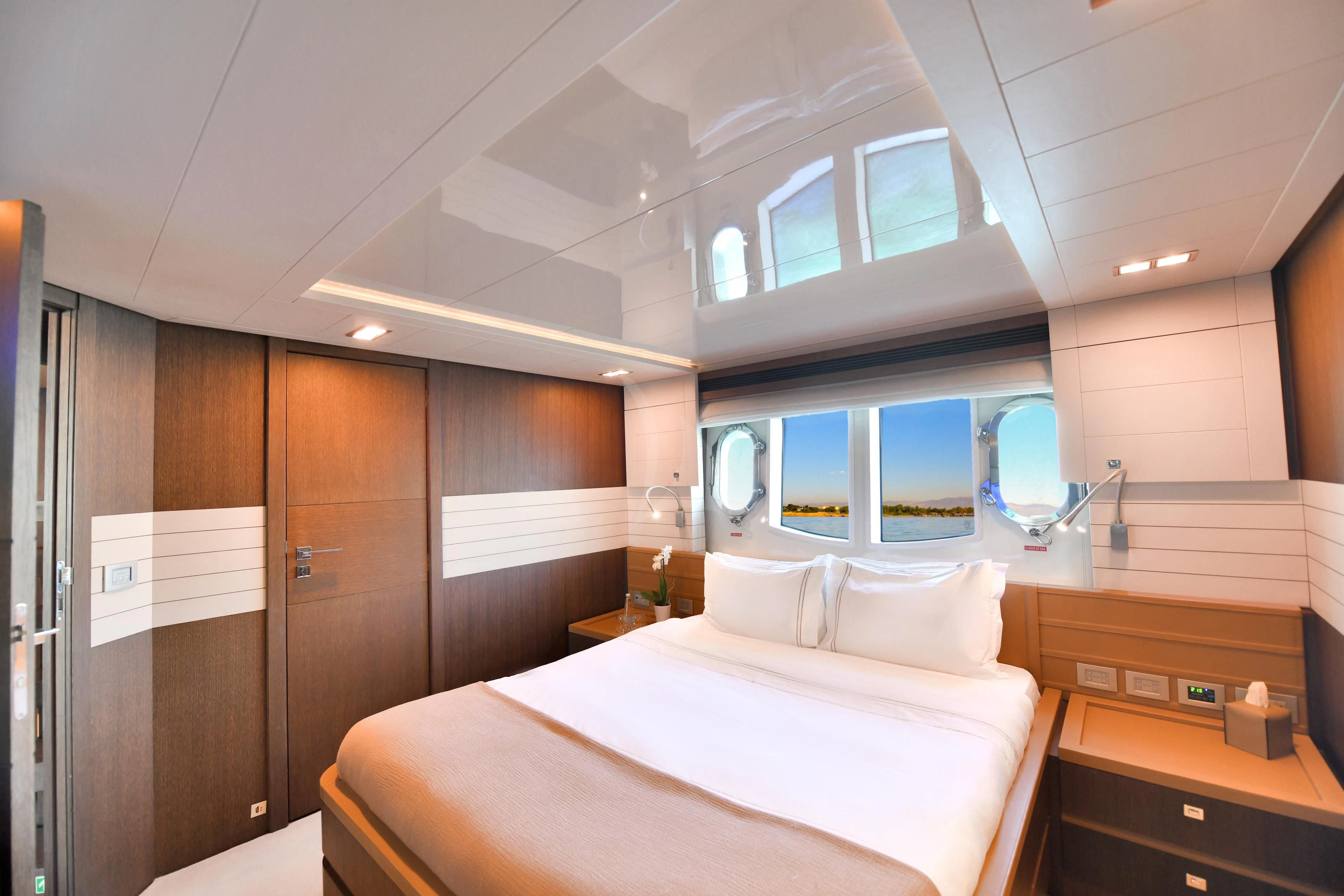 a room with a bed and a mirror aboard INFINITAS Yacht for Charter