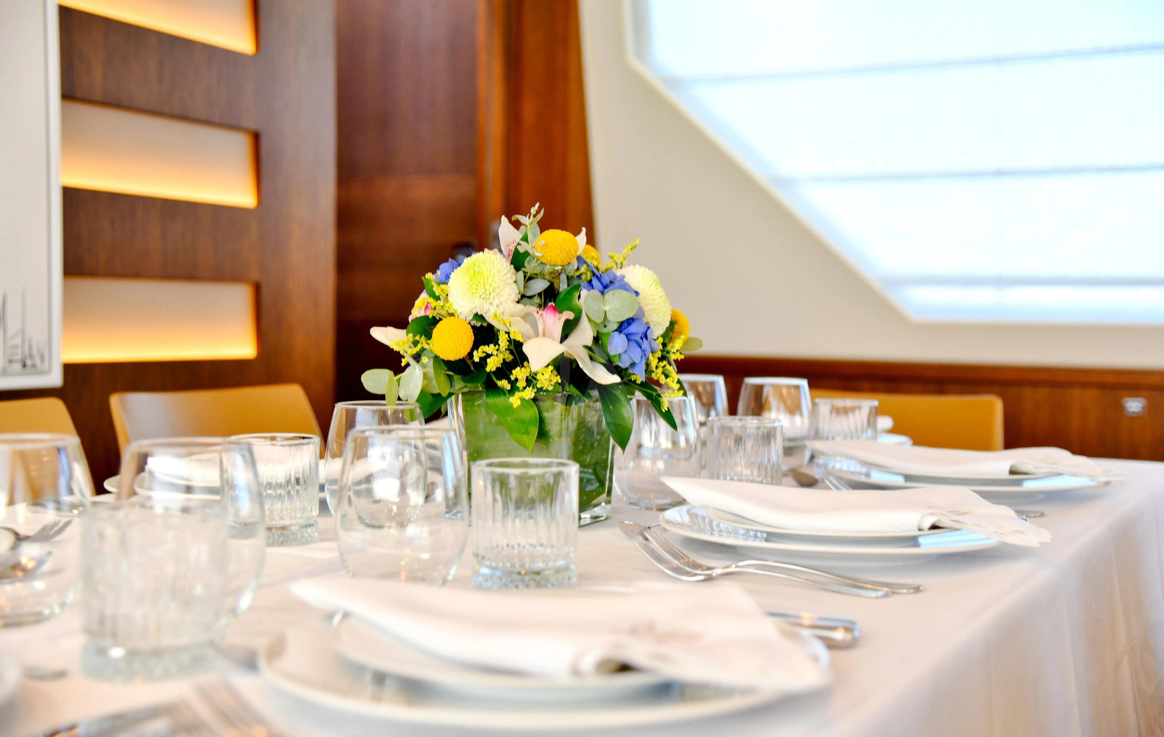 a table with glasses and plates aboard INFINITAS Yacht for Charter