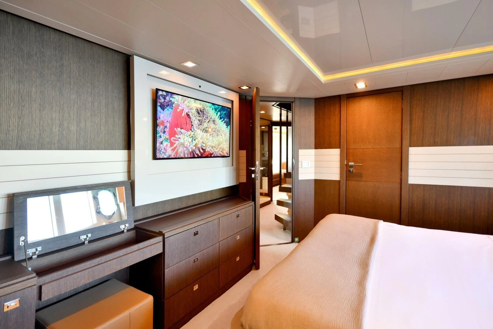 a room with a bed and a television aboard INFINITAS Yacht for Charter