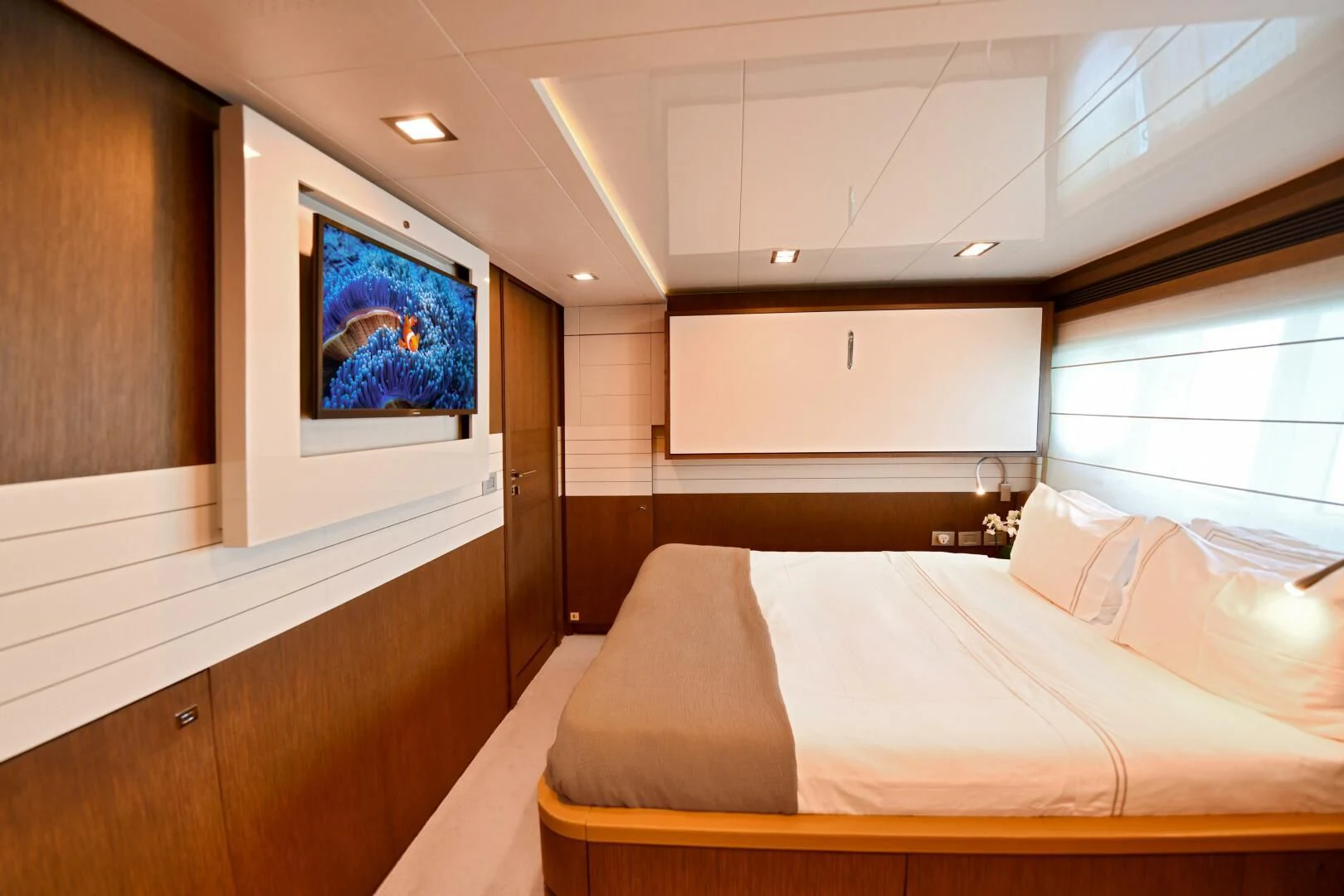 a room with a bed and a window aboard INFINITAS Yacht for Charter