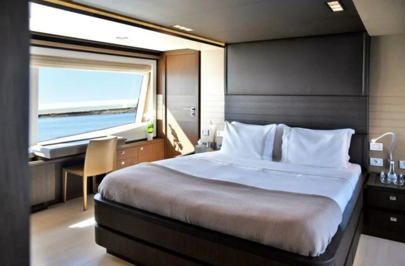 a bed with a white sheet aboard INFINITAS Yacht for Charter