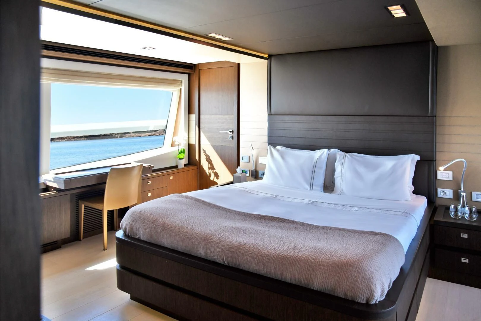 a bed with a white sheet aboard INFINITAS Yacht for Charter