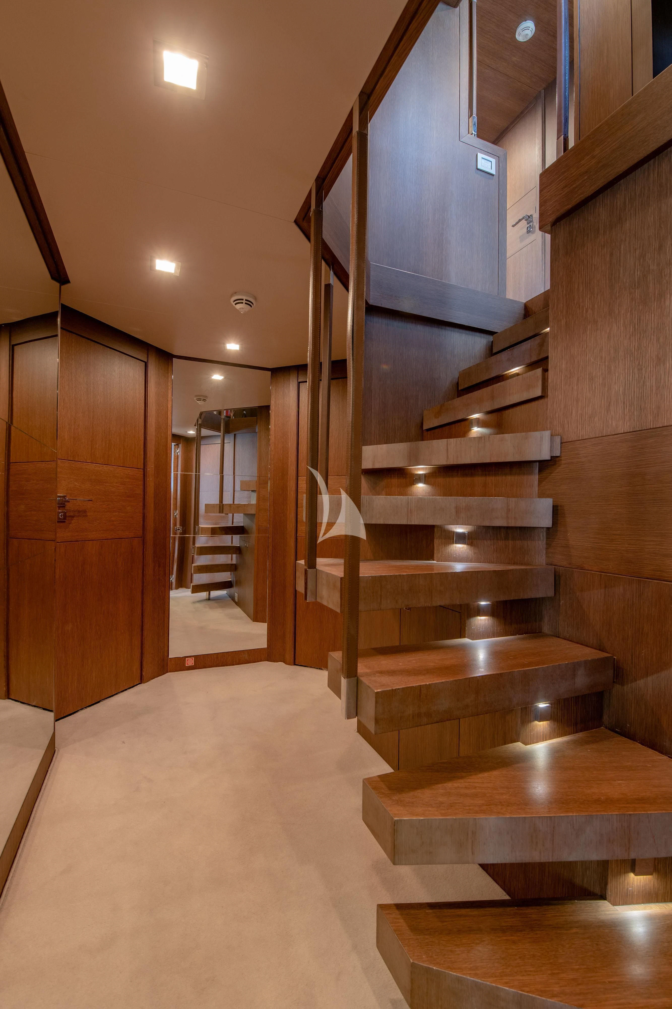a wooden staircase in a house aboard INFINITAS Yacht for Charter