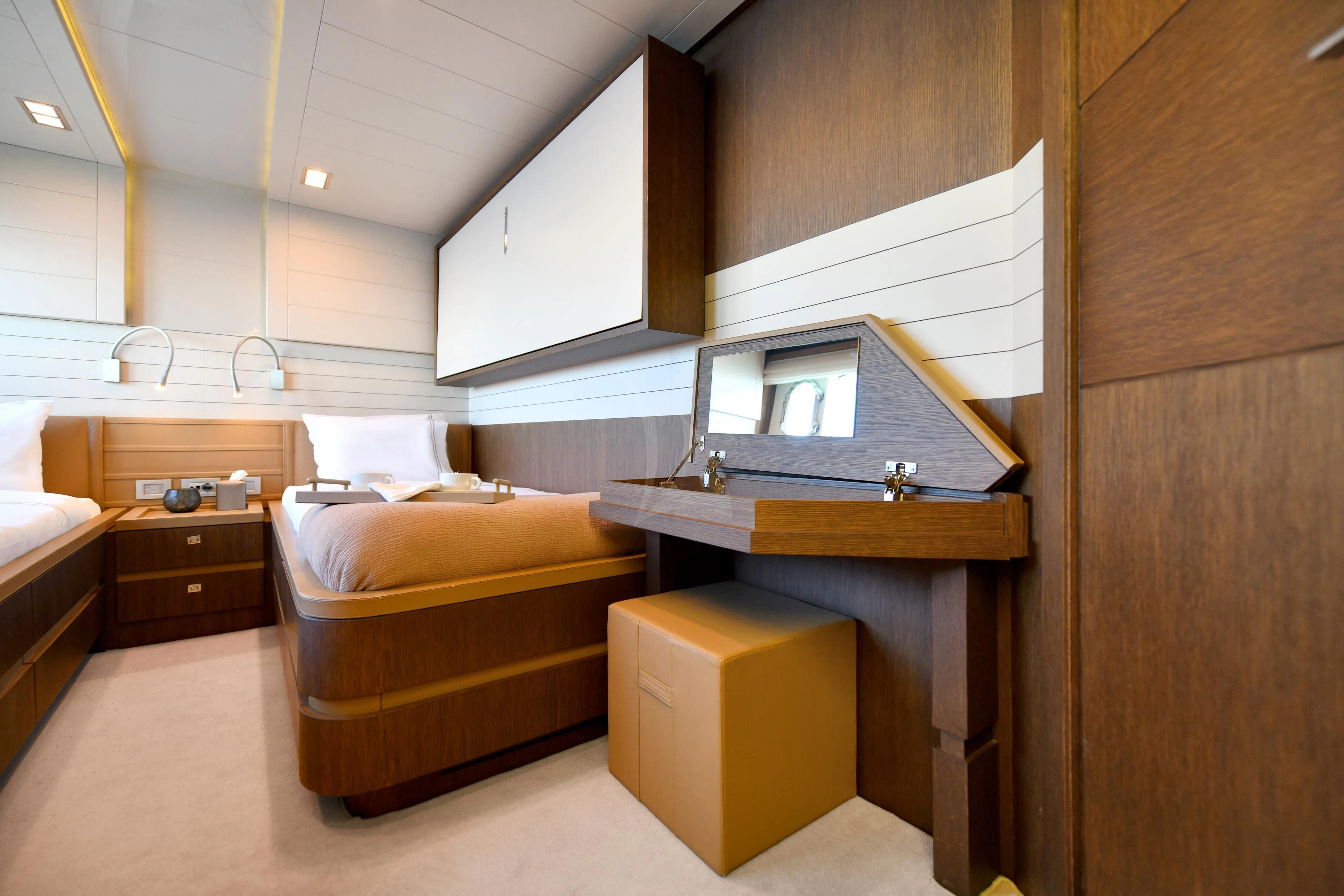 a room with a bed and a desk aboard INFINITAS Yacht for Charter