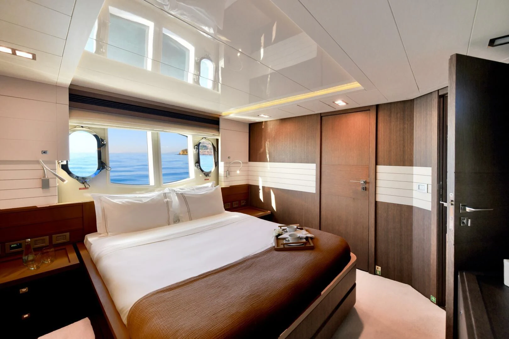 a room with a bed and a mirror aboard INFINITAS Yacht for Charter