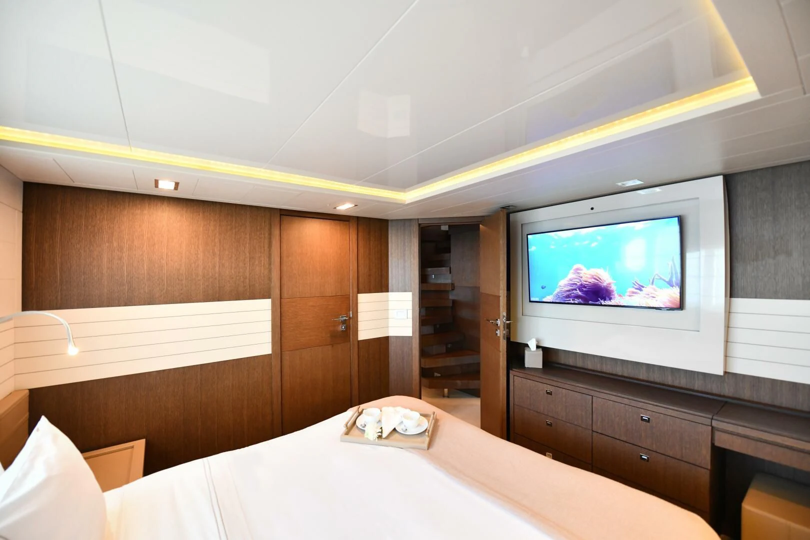 a room with a bed and tv aboard INFINITAS Yacht for Charter