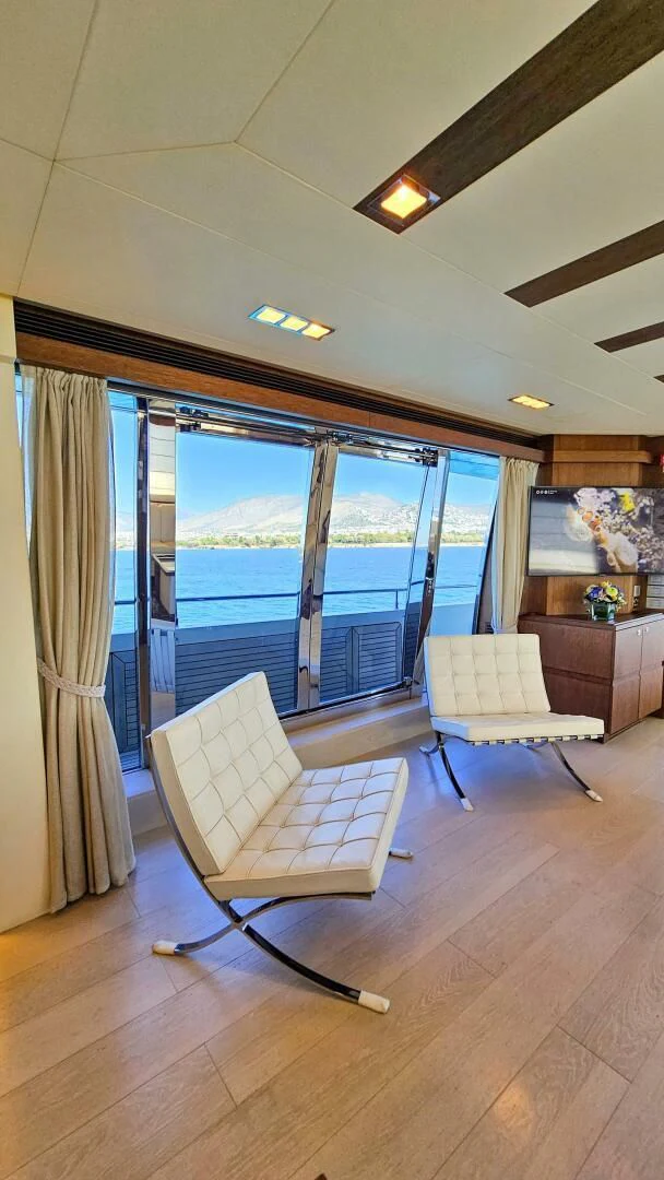 a room with a view of the ocean and a deck aboard INFINITAS Yacht for Charter