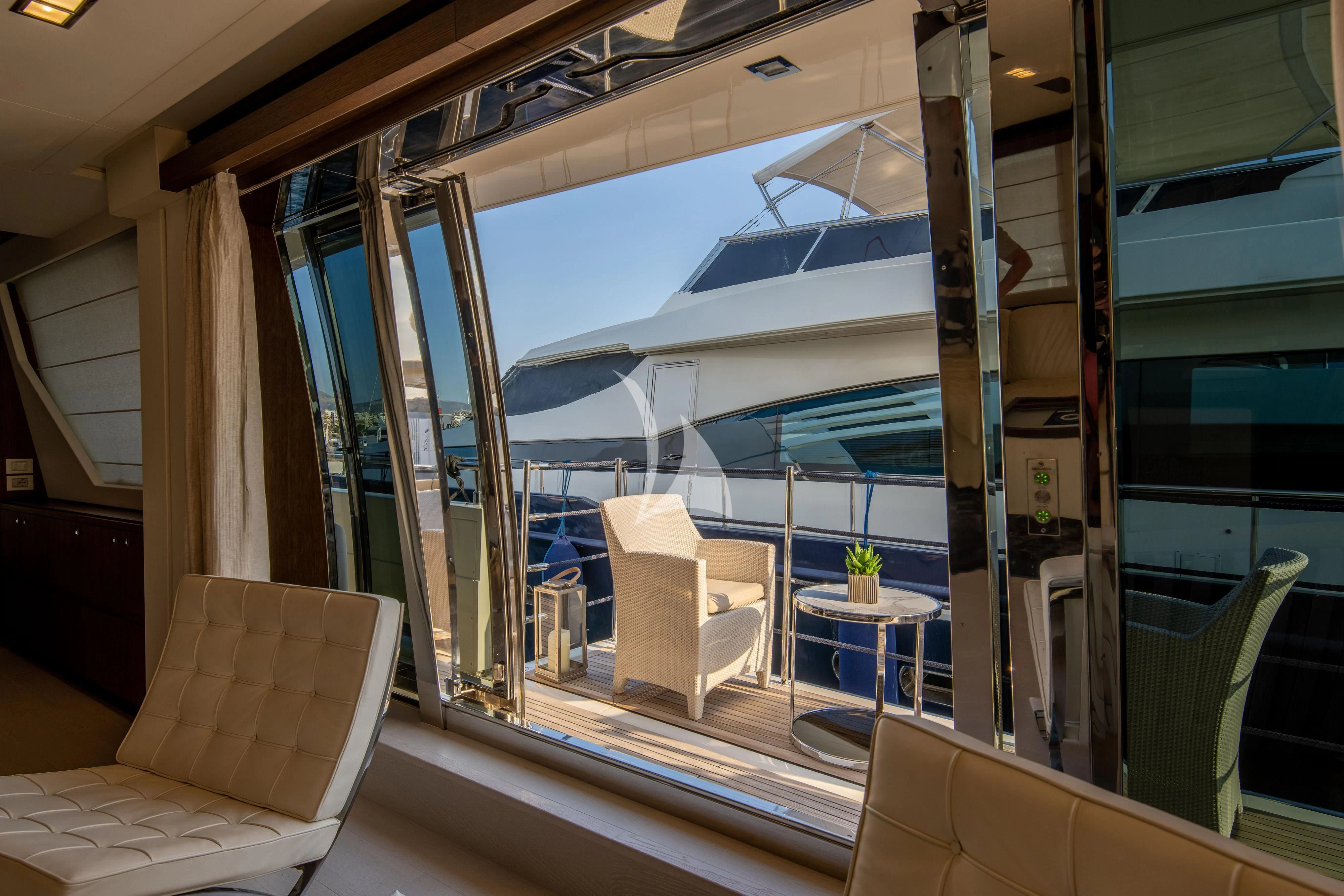 a room with a glass wall and a couch and a table aboard INFINITAS Yacht for Charter