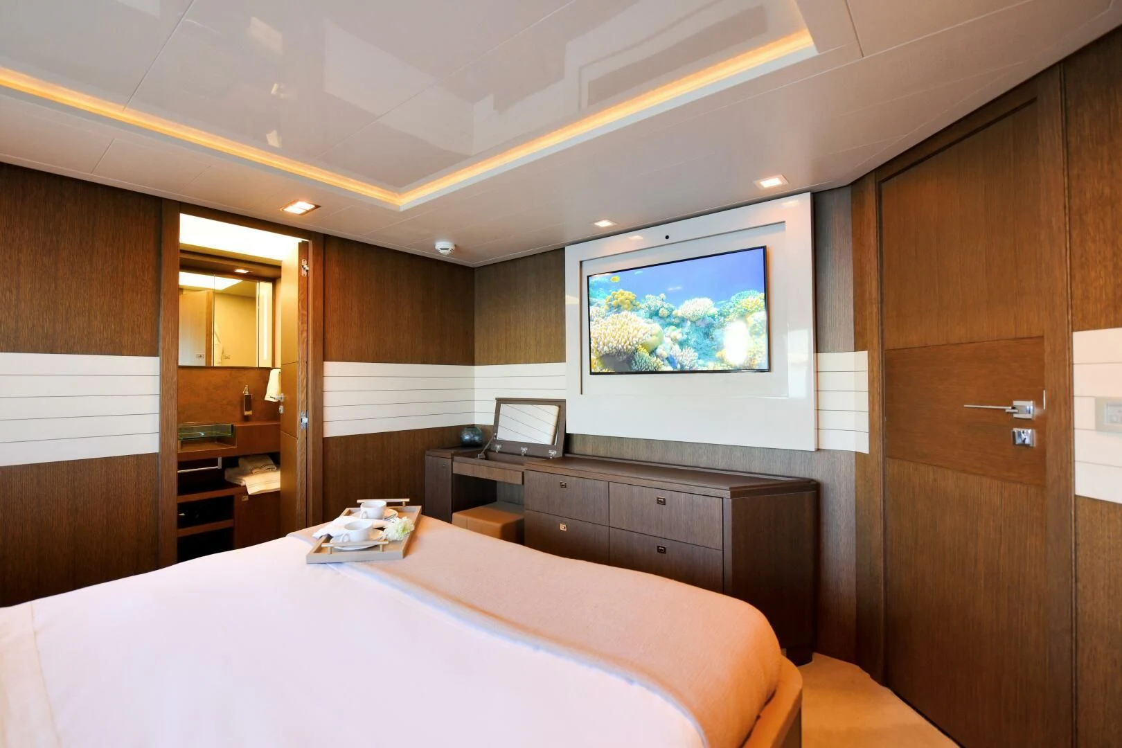 a room with a bed and a television aboard INFINITAS Yacht for Charter
