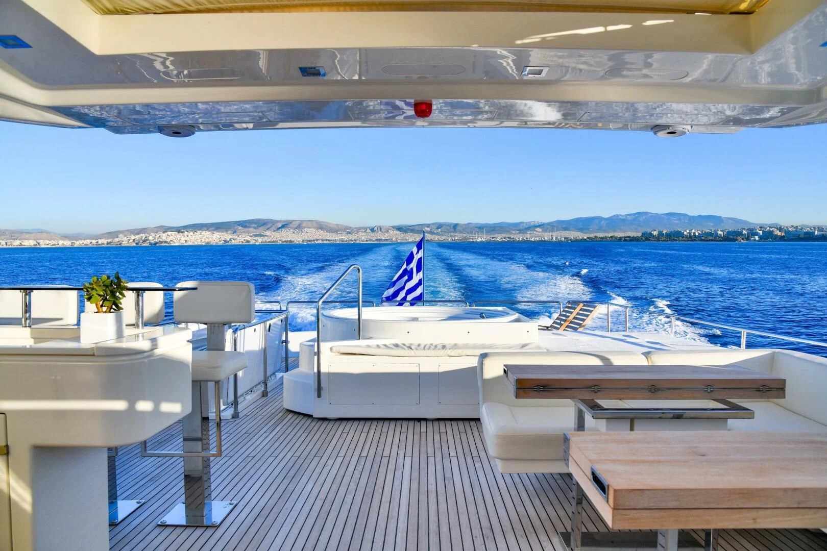 a deck with chairs and tables on it by the water aboard INFINITAS Yacht for Charter