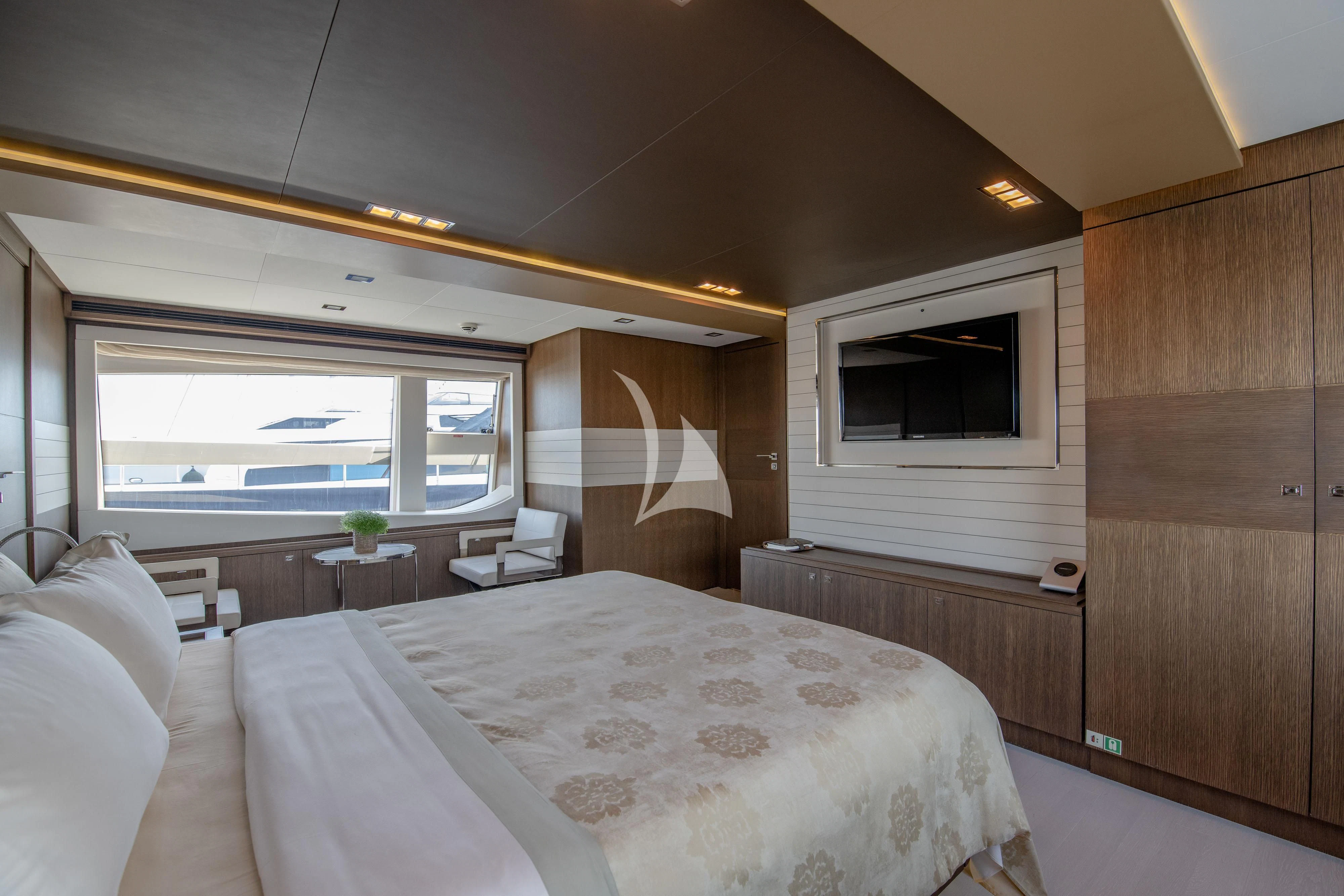 a room with a bed and a television aboard INFINITAS Yacht for Charter