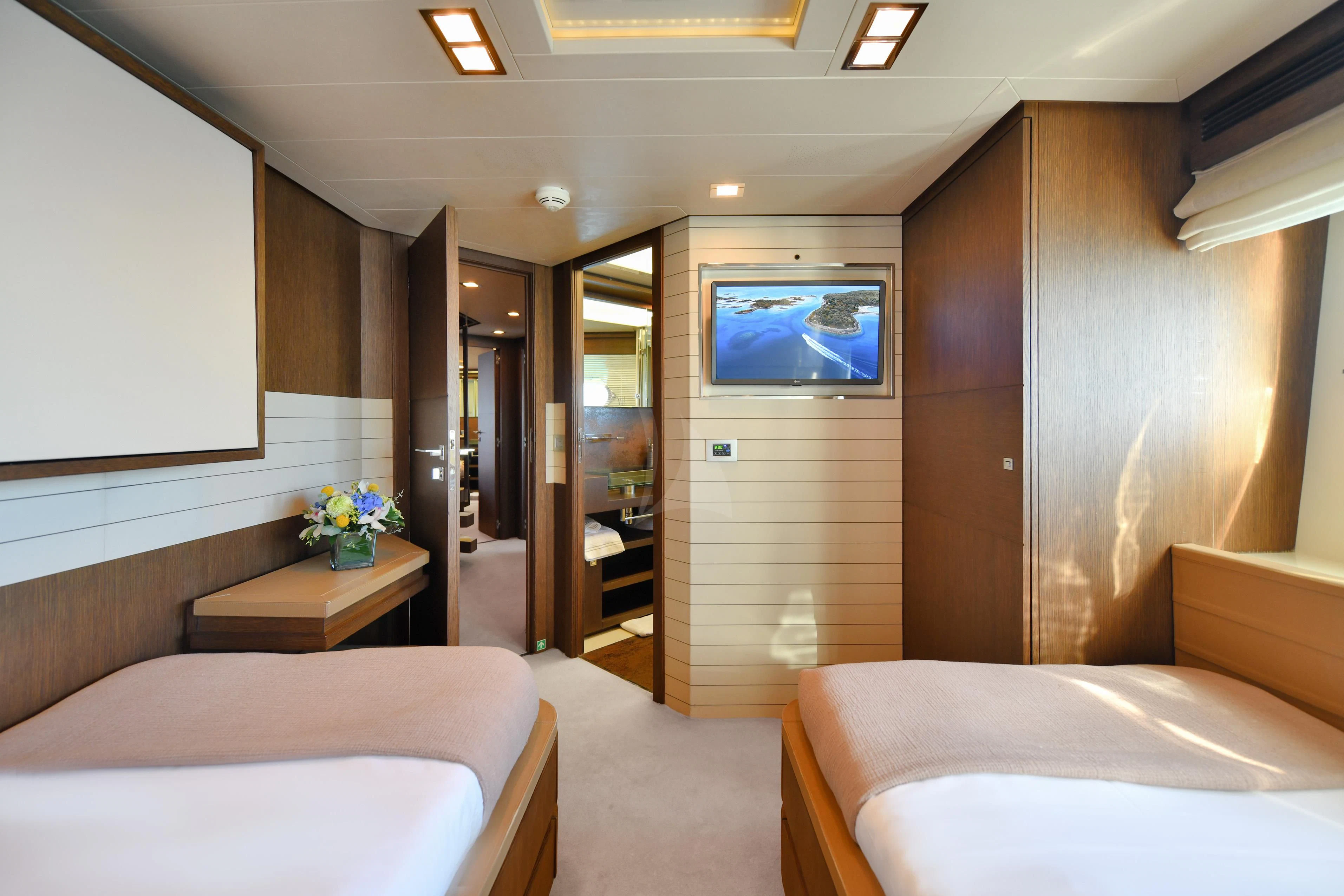 a room with a bed and a tv on the wall aboard INFINITAS Yacht for Charter