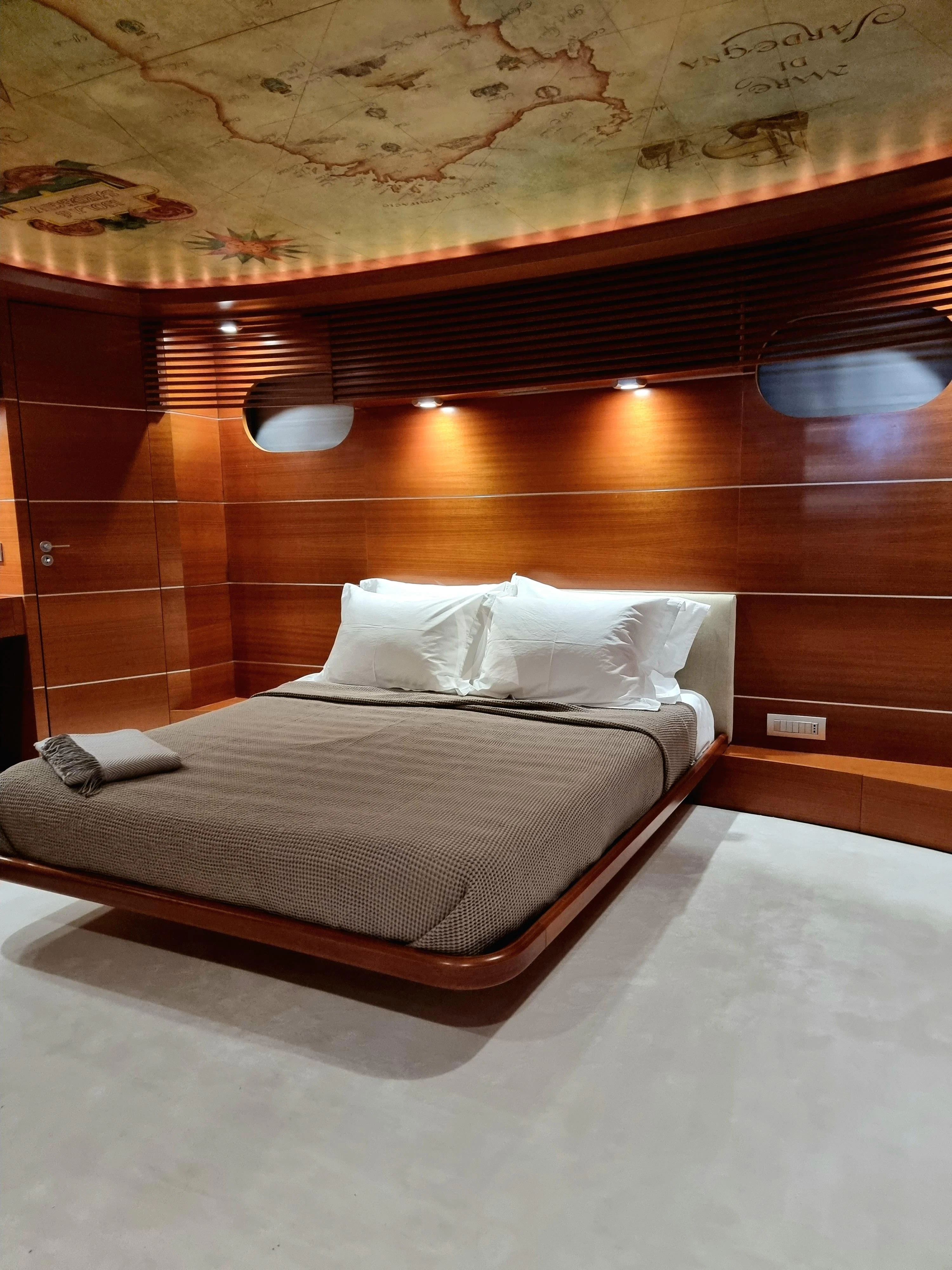 a bed with a wooden headboard aboard SATORI Yacht for Sale