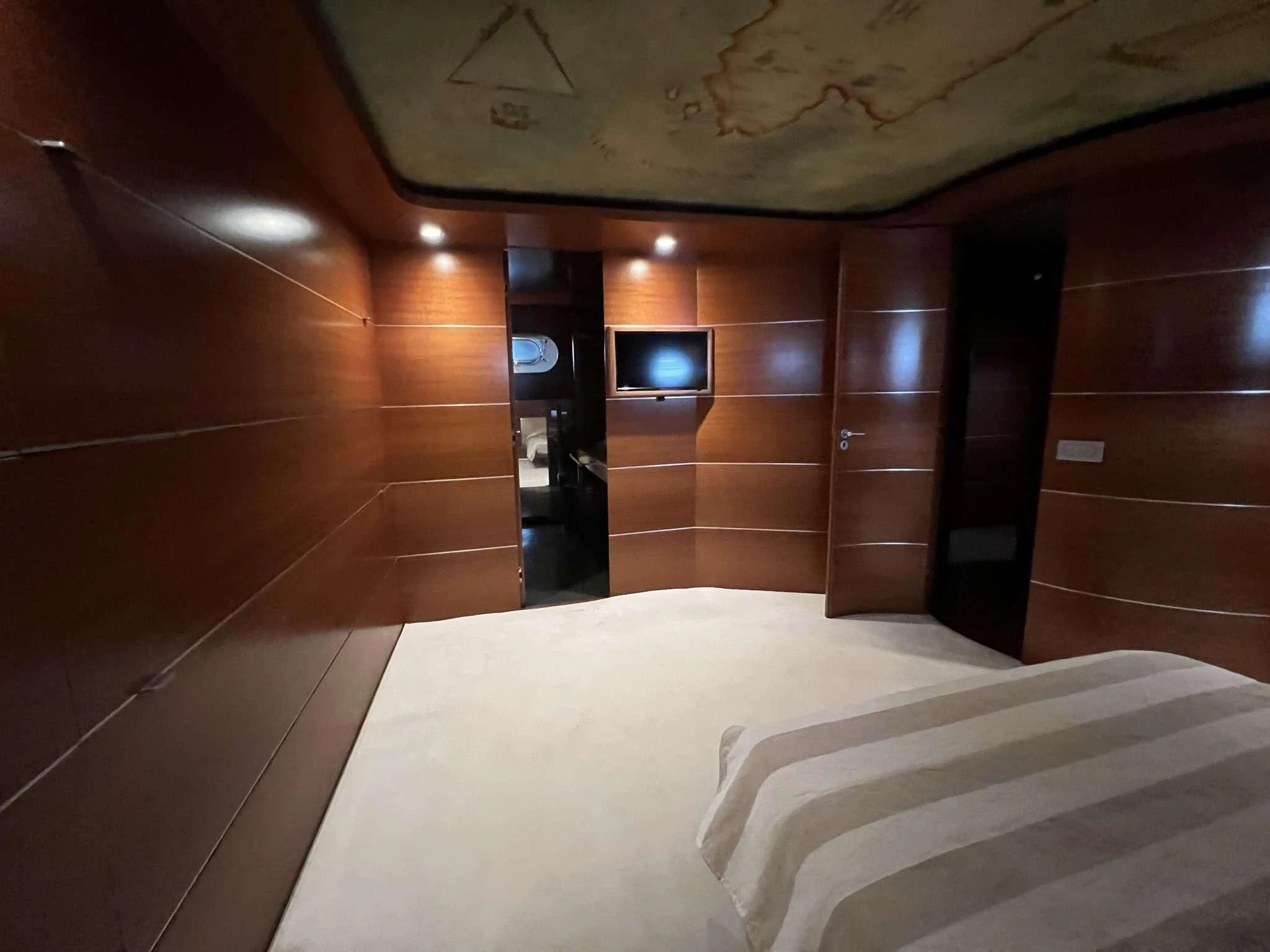 a room with a bed and a tv on the wall aboard SATORI Yacht for Sale