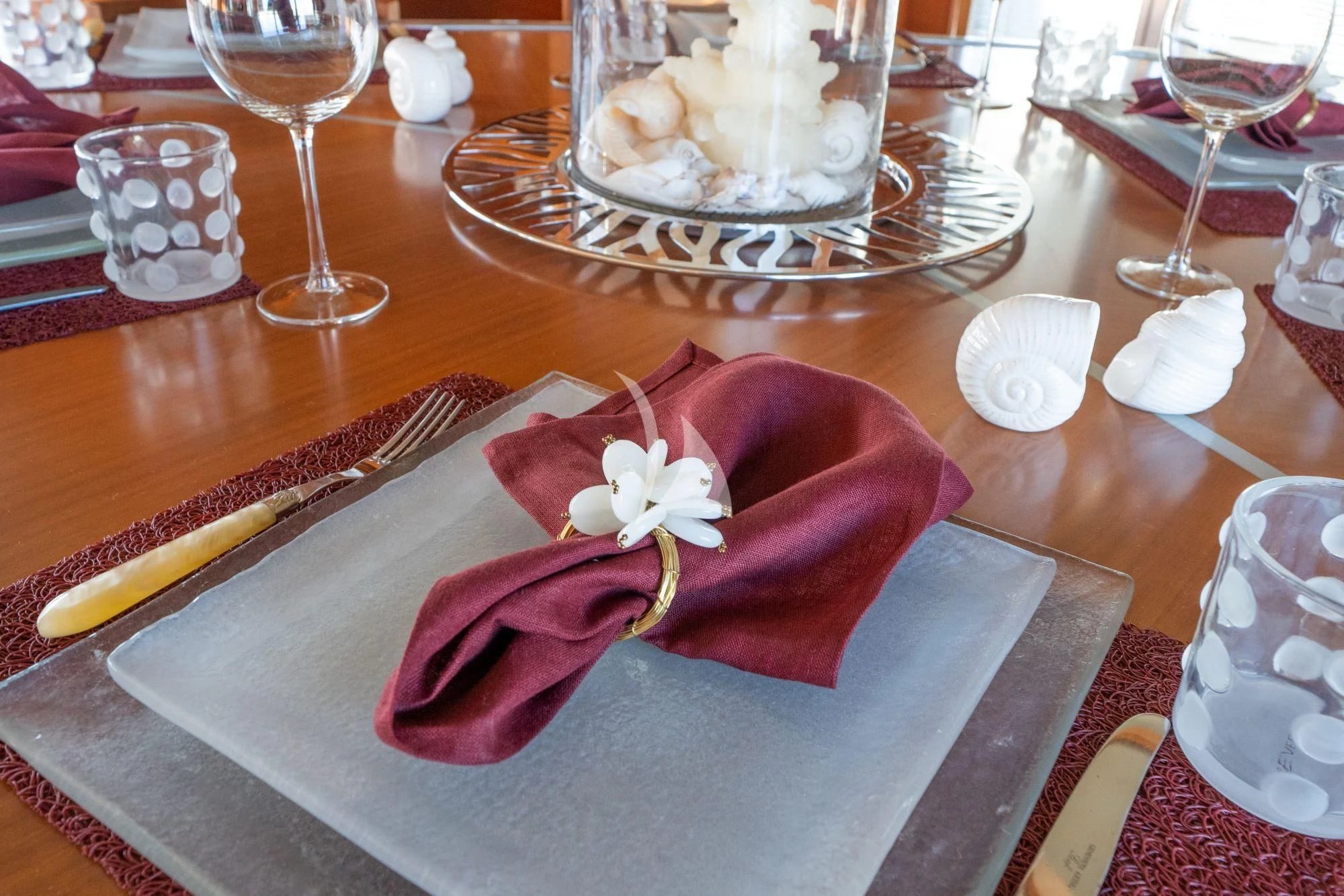 a table with a plate of food and glasses of wine aboard SATORI Yacht for Sale