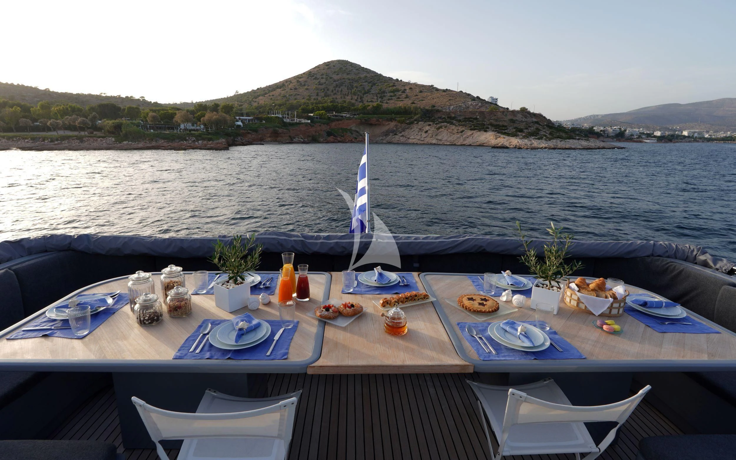 a table with food on it by the water aboard SATORI Yacht for Sale