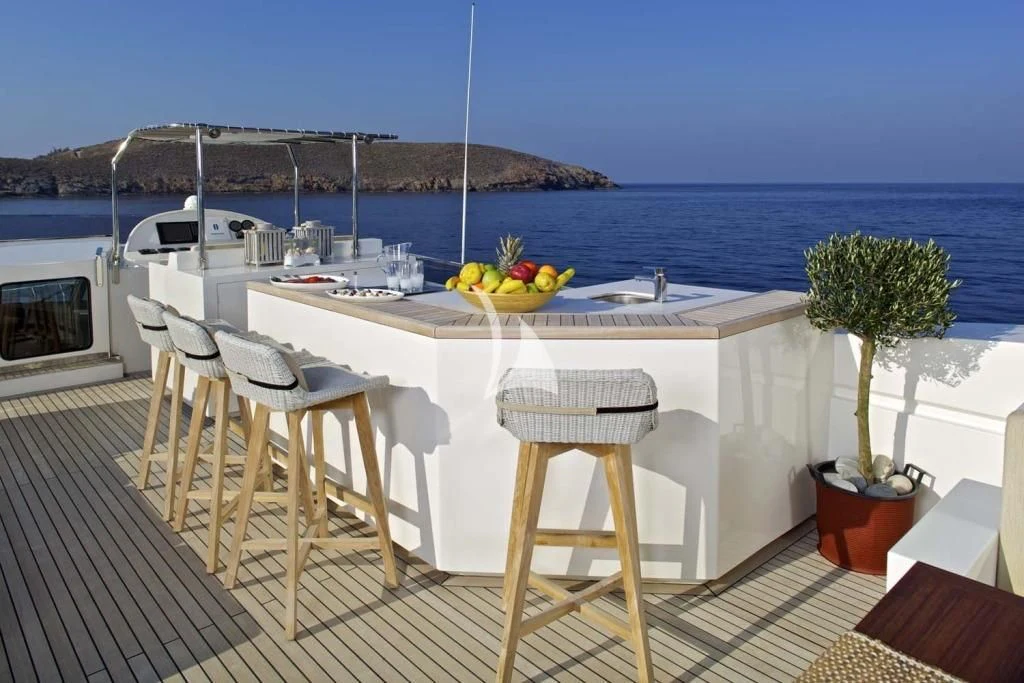 a table and chairs on a deck overlooking the ocean aboard SANJANA Yacht for Sale