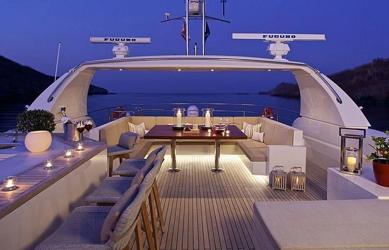 a large pool with a deck and a deck with a large ship in the background aboard SANJANA Yacht for Sale