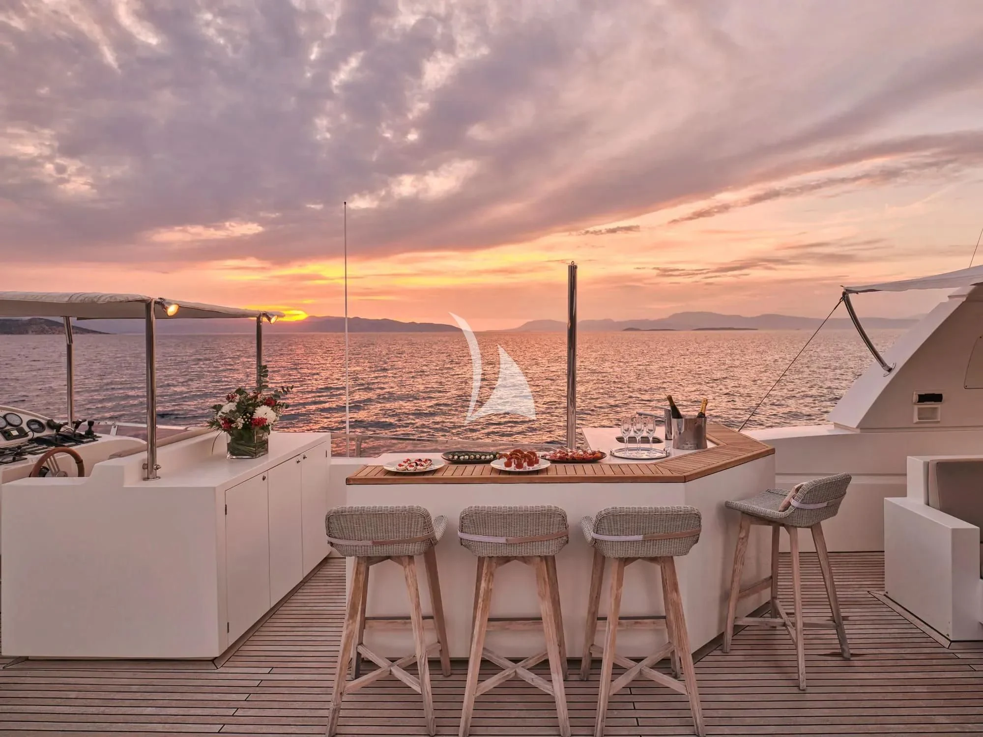 a table and chairs on a deck overlooking a body of water aboard SANJANA Yacht for Sale
