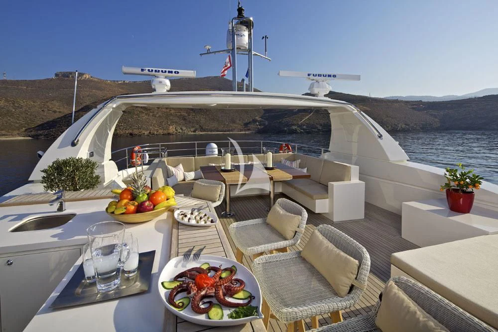 a table with a plate of food and a helicopter in the background aboard SANJANA Yacht for Sale