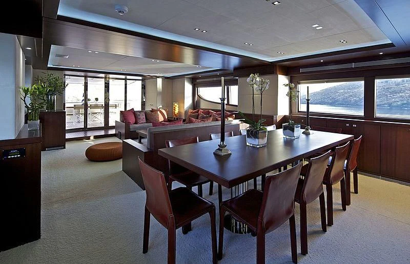 a large dining table in a living room aboard SANJANA Yacht for Sale