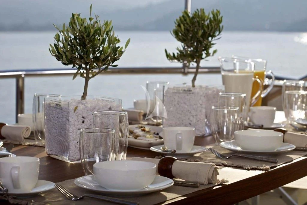a table with plates and glasses on it aboard SANJANA Yacht for Sale