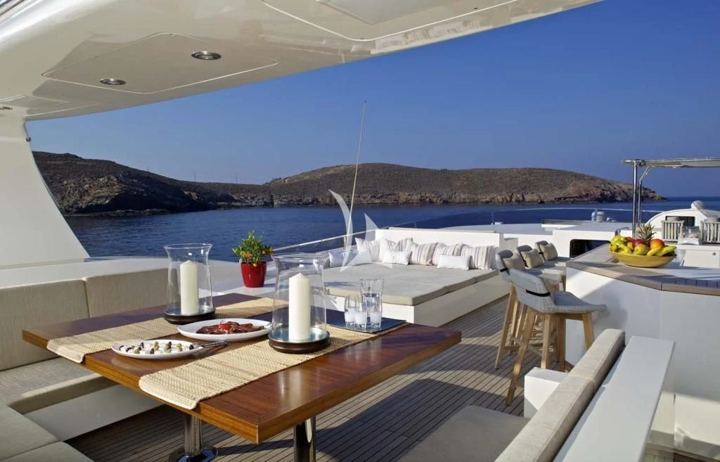 a table with plates and glasses on it by a body of water aboard SANJANA Yacht for Sale