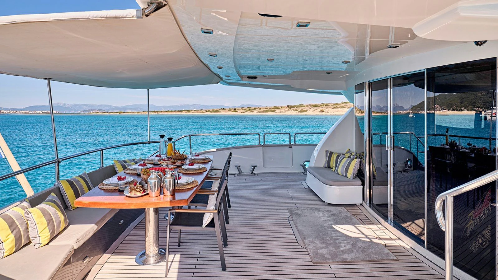 a deck with a table and chairs on it aboard SANJANA Yacht for Sale