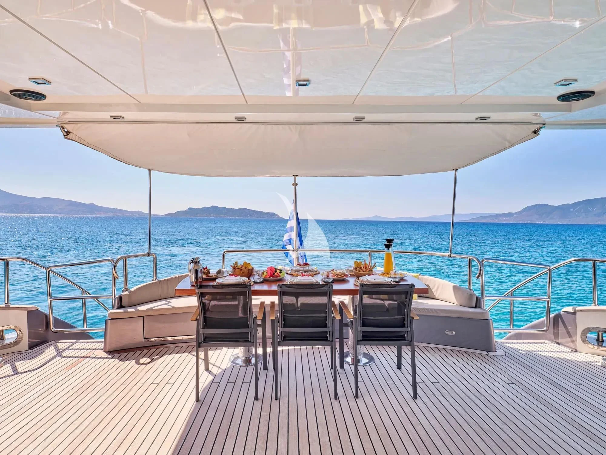 a deck with chairs and a table on it aboard SANJANA Yacht for Sale