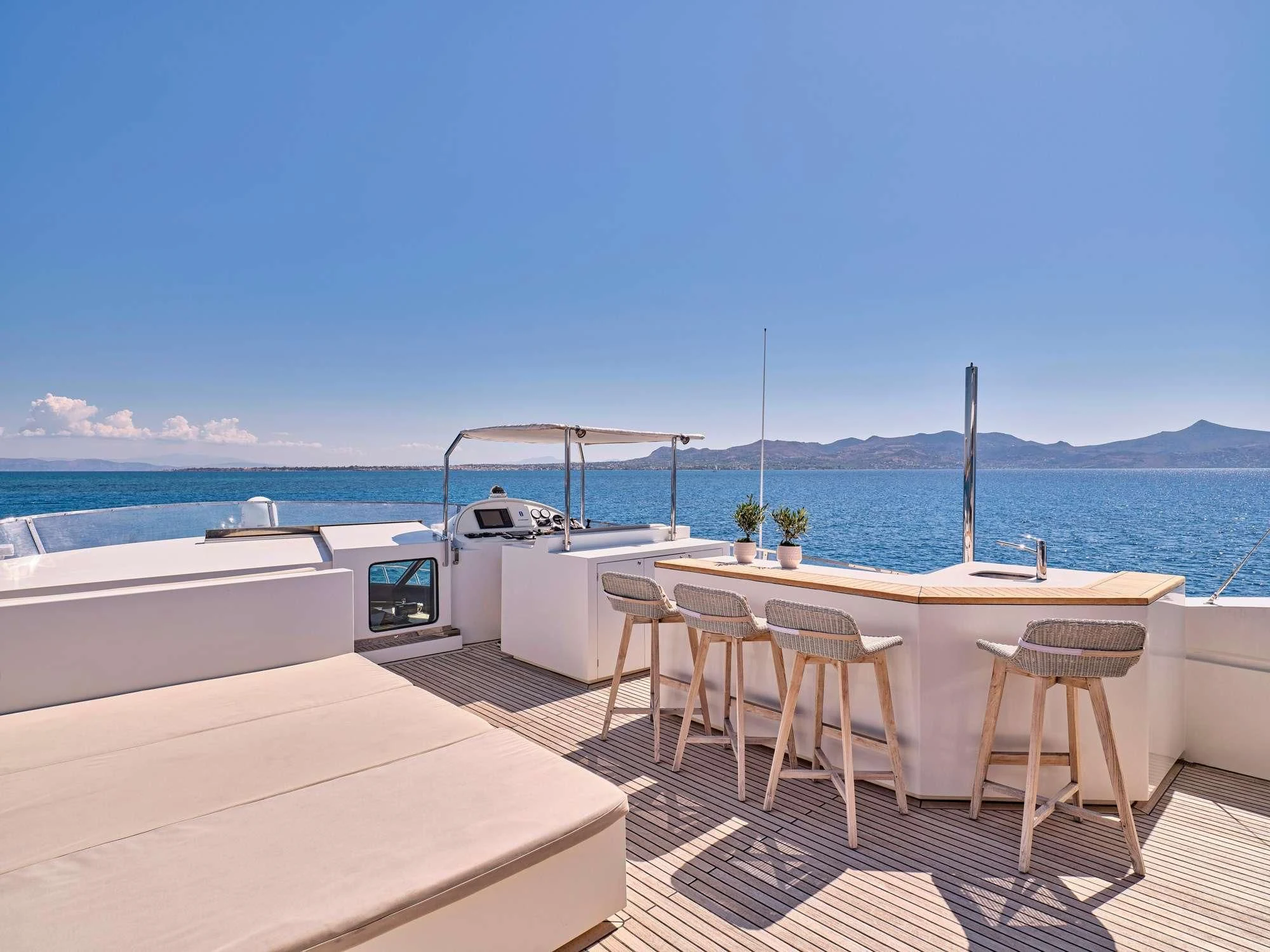 a deck with tables and chairs on it by the water aboard SANJANA Yacht for Sale