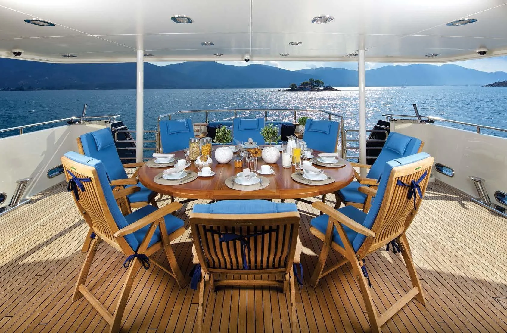 a table set for a meal on a deck overlooking the ocean aboard MAGIX Yacht for Sale