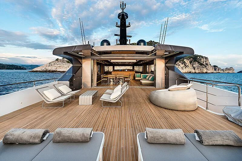 a deck with a large body of water and a large ship in the background aboard LADY NINA Yacht for Sale