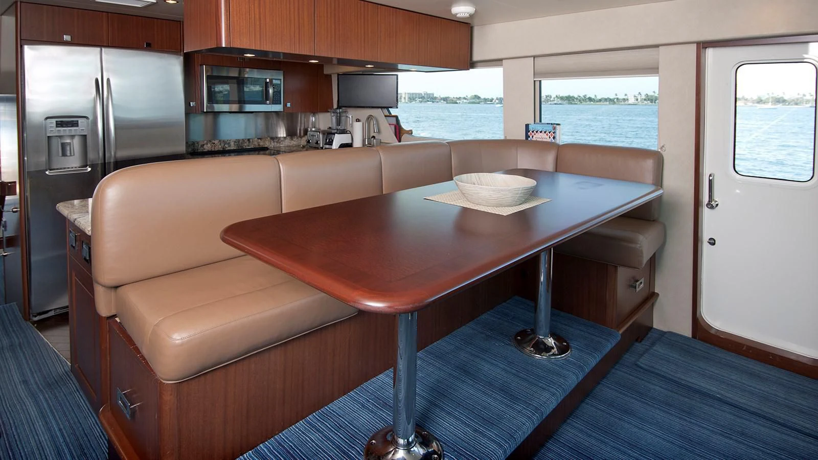 a kitchen with a table and chairs aboard MONCRII Yacht for Sale