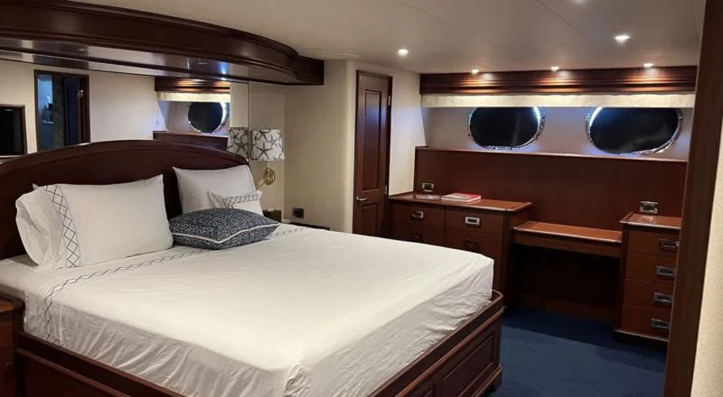 a bed with a white sheet and pillows aboard MONCRII Yacht for Sale