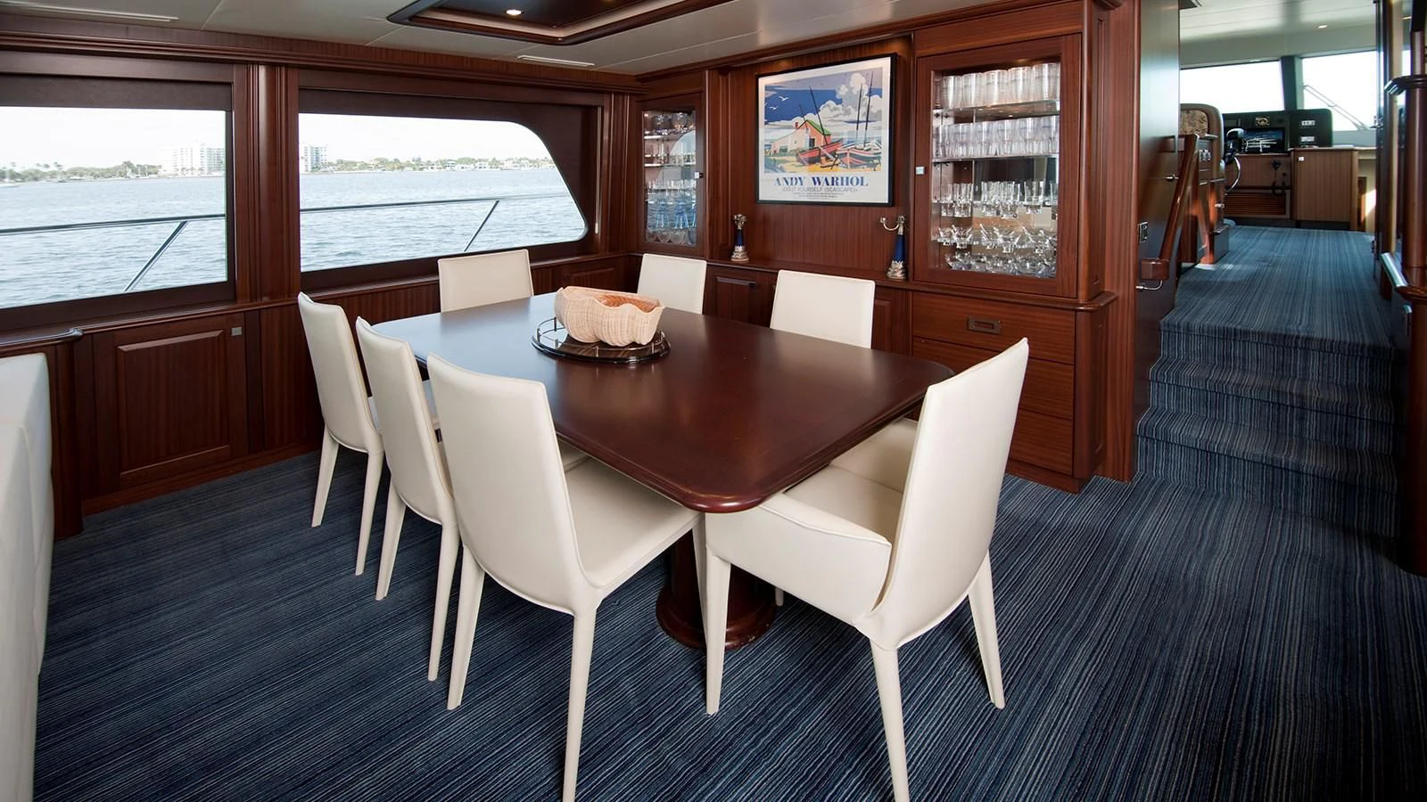 a dining table and chairs in a room with a window aboard MONCRII Yacht for Sale