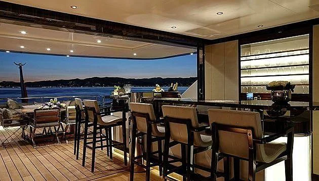 a room with a table chairs and a large body of water aboard EXCELLENCE V Yacht for Sale