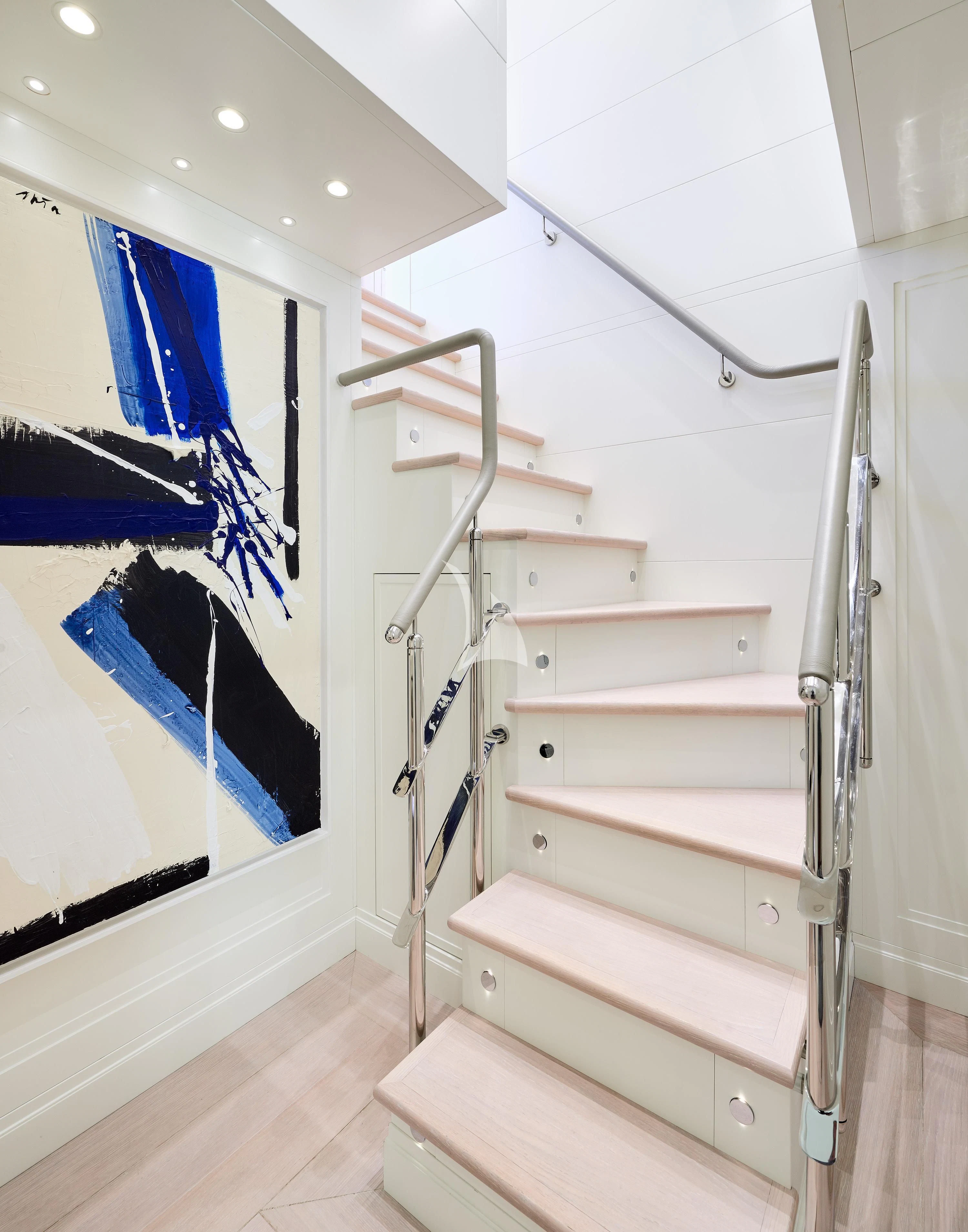 a white staircase with a painting on the wall aboard 2011 SANLORENZO SD92 FLYBRIDGE Yacht for Sale