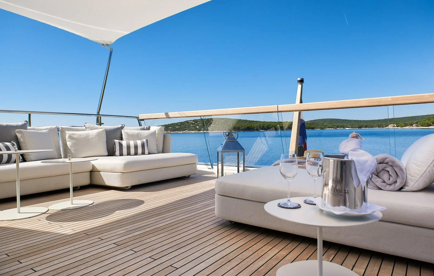a white couch and a table on a deck with a blue sky aboard 2011 SANLORENZO SD92 FLYBRIDGE Yacht for Sale