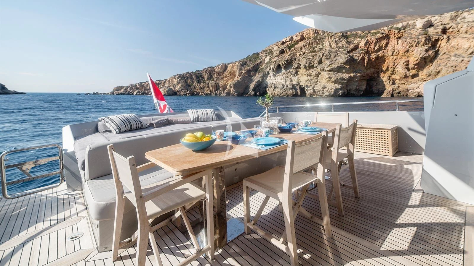 a table and chairs on a deck overlooking a body of water aboard ELEVEN I Yacht for Sale