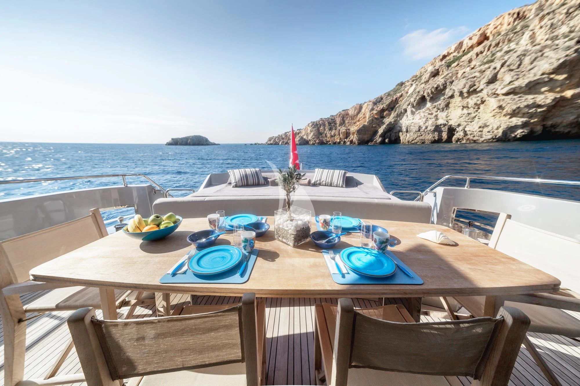 a table with plates and bowls on it by the water aboard ELEVEN I Yacht for Sale