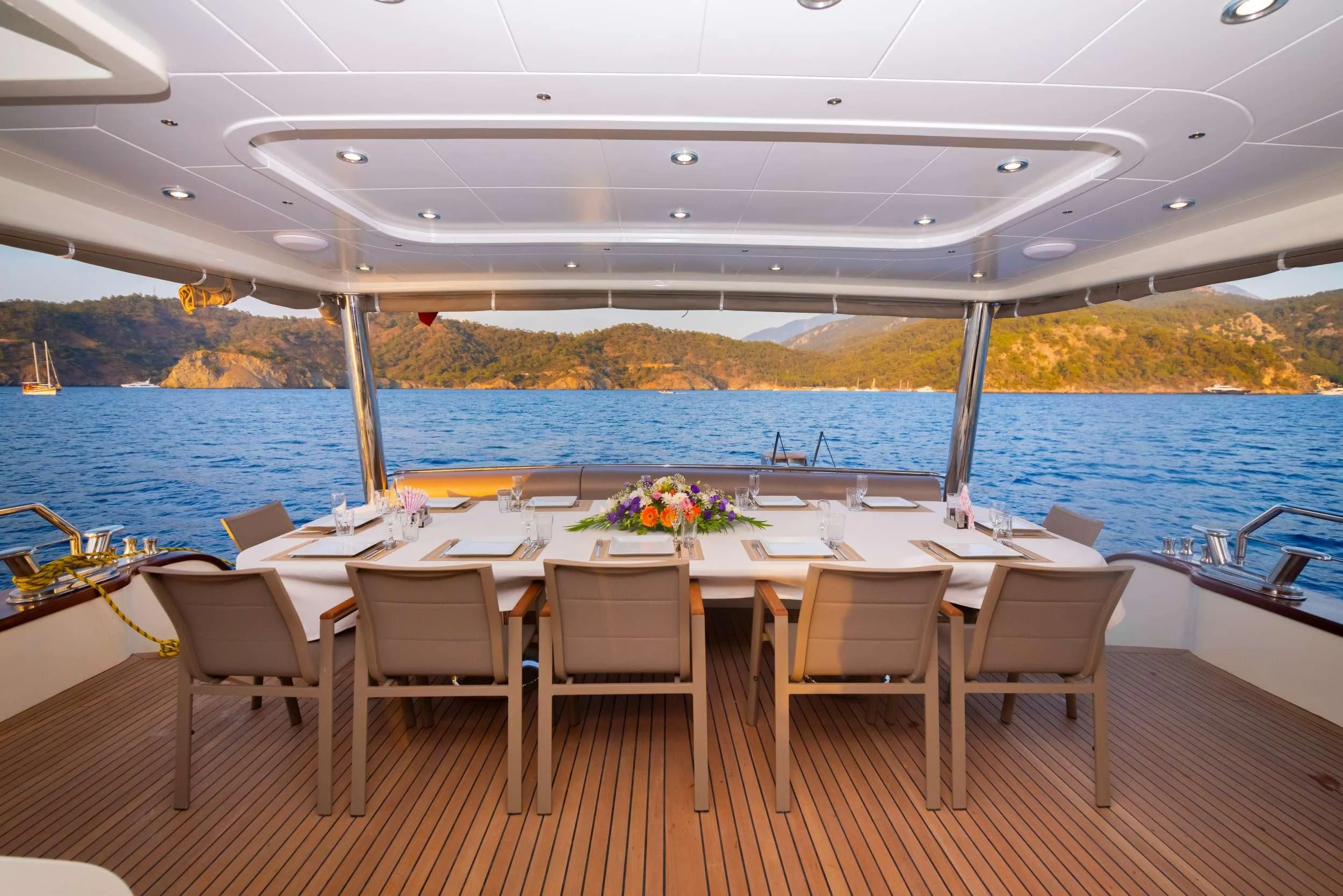 a table set for a dinner on a deck overlooking a body of water aboard 88 YACHT Yacht for Sale