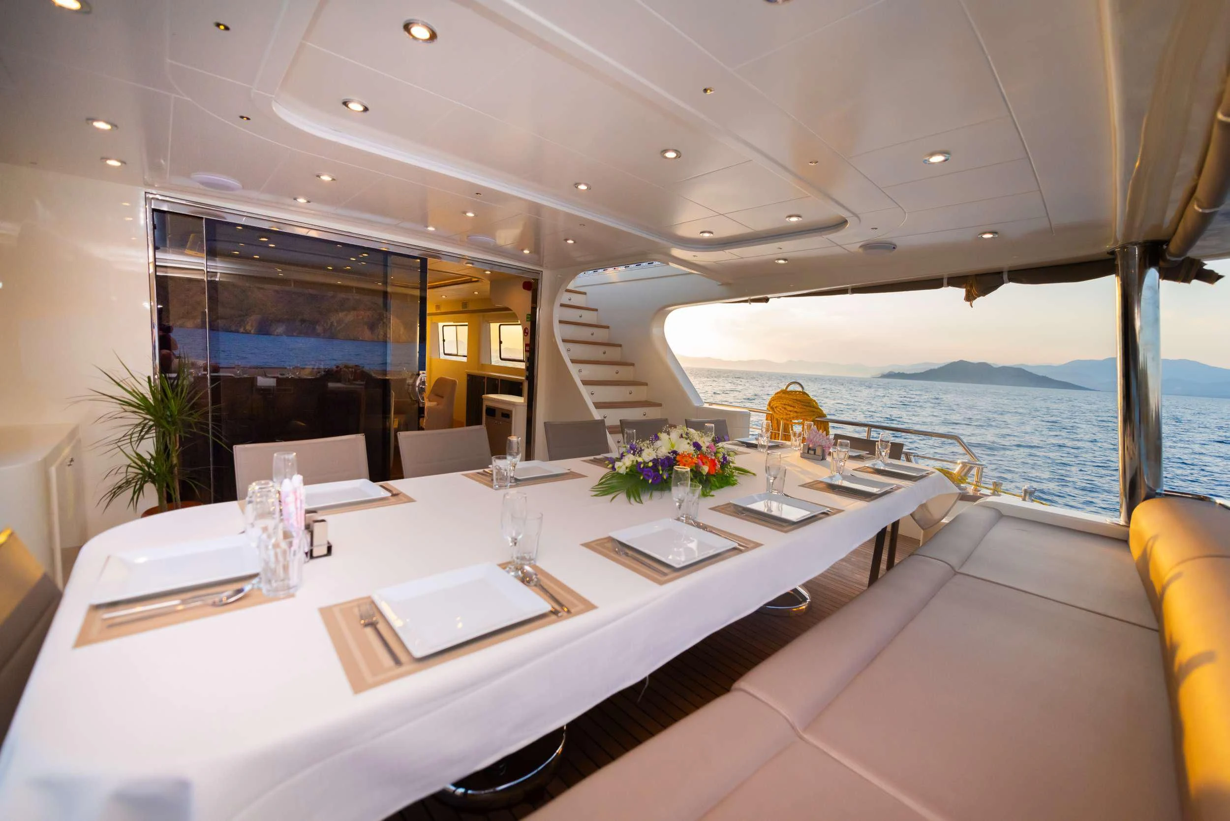 a table with chairs and a view of the ocean aboard 88 YACHT Yacht for Sale