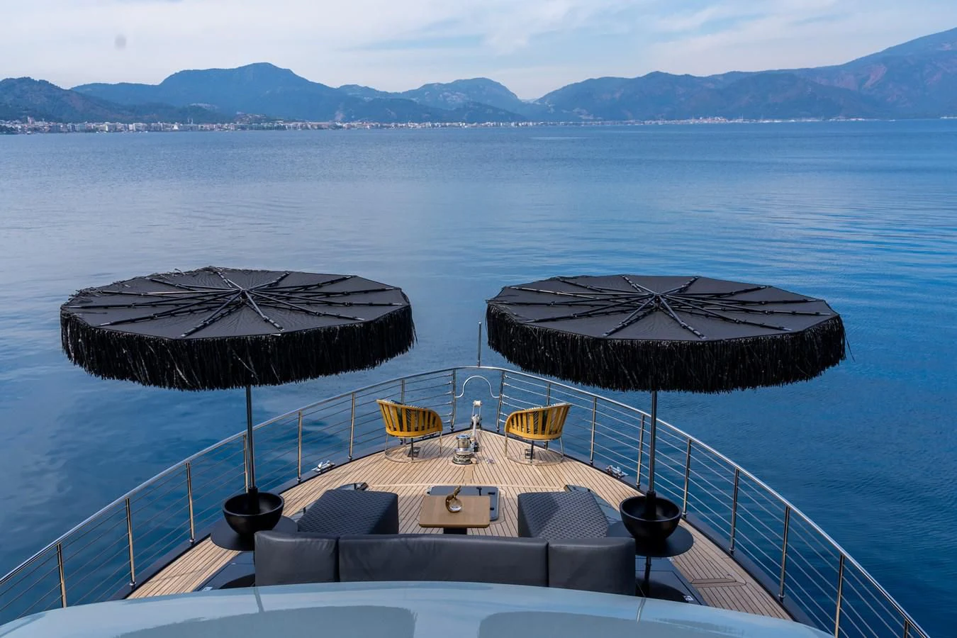 a deck with chairs and a table on it in the water aboard NOAM Yacht for Sale