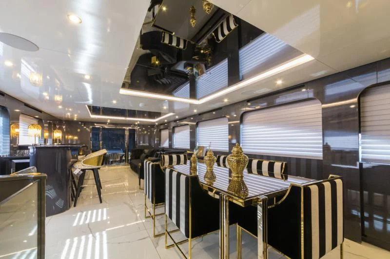 a large room with a table and chairs aboard NOAM Yacht for Sale