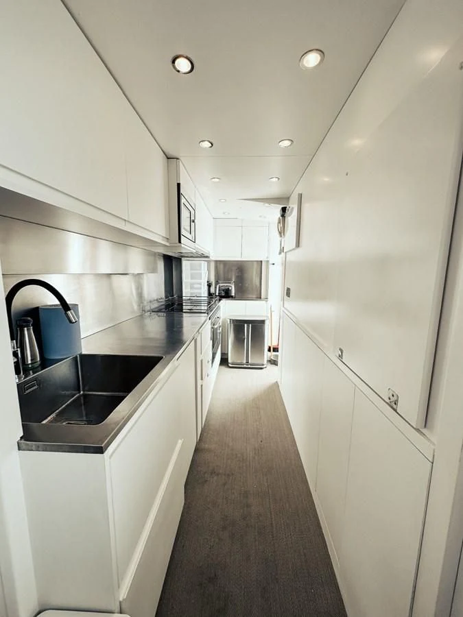 a kitchen with white cabinets aboard LAZIZA Yacht for Sale