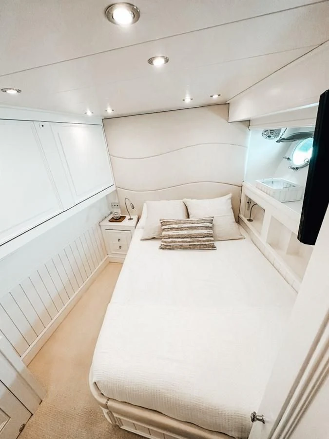 a white bedroom with a bed aboard LAZIZA Yacht for Sale