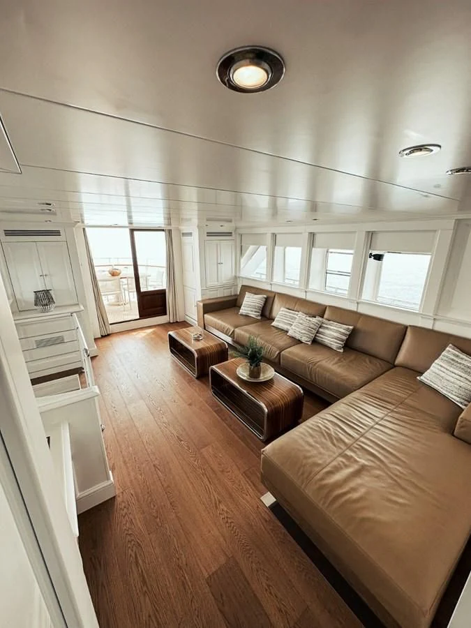 a living room with a wood floor aboard LAZIZA Yacht for Sale
